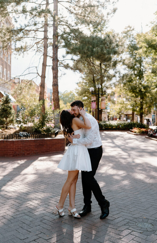 Couple hugging and laughing on Pearl Street during engagement session