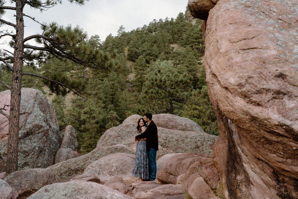 Fiancé hugging fiancée on a hike during an engagement session in Boulder, CO