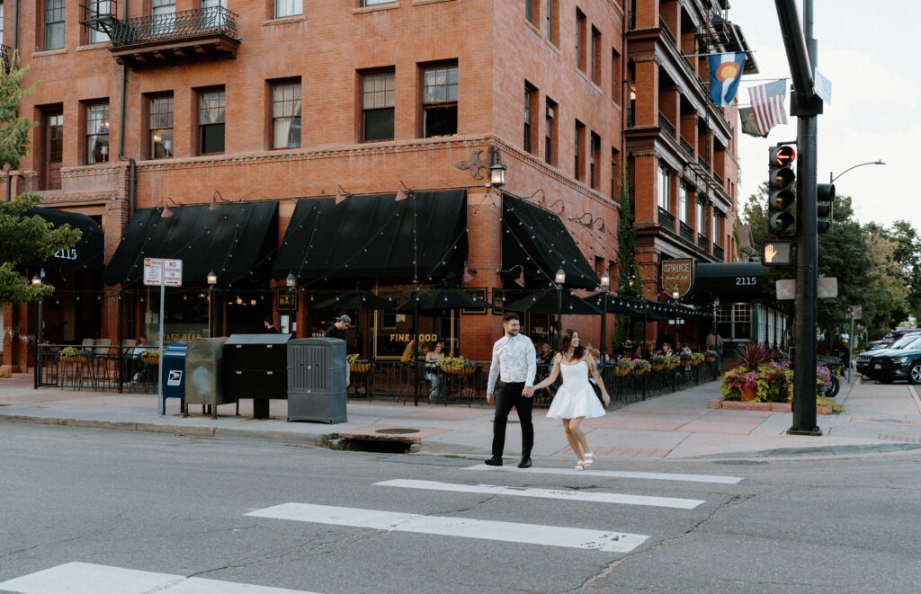 Couple crossing the street during engagement session on Pearl Street