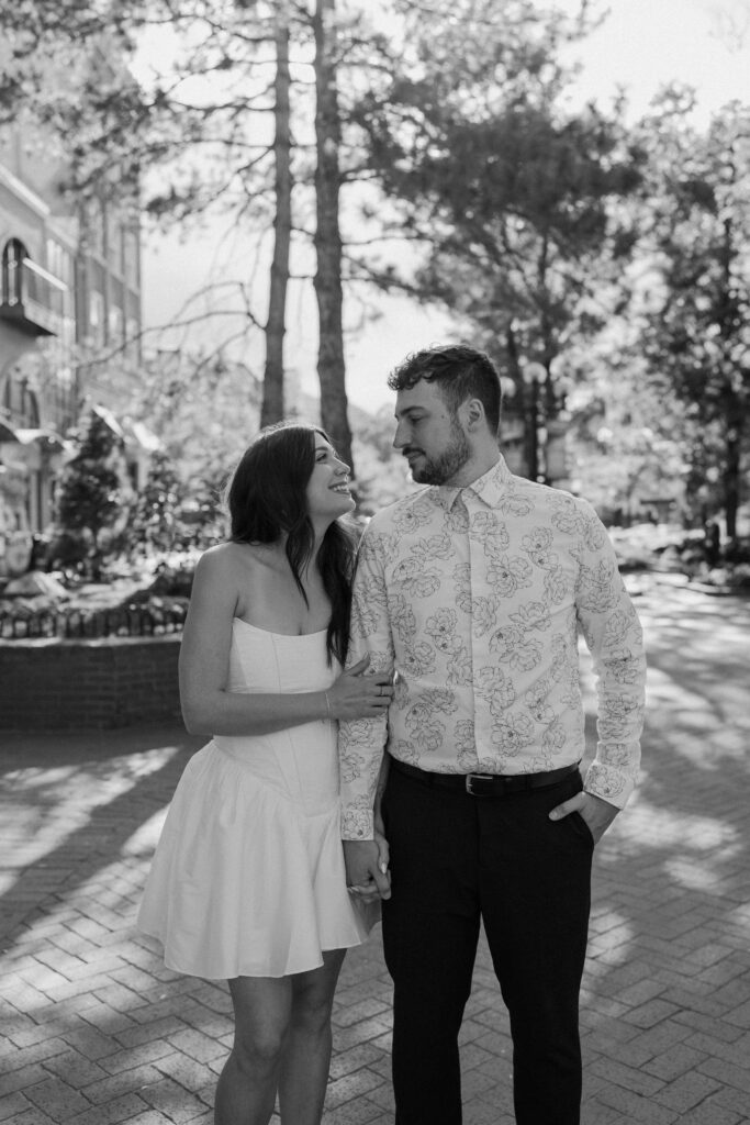 Couple smiling at each other during an engagement session on Pearl Street