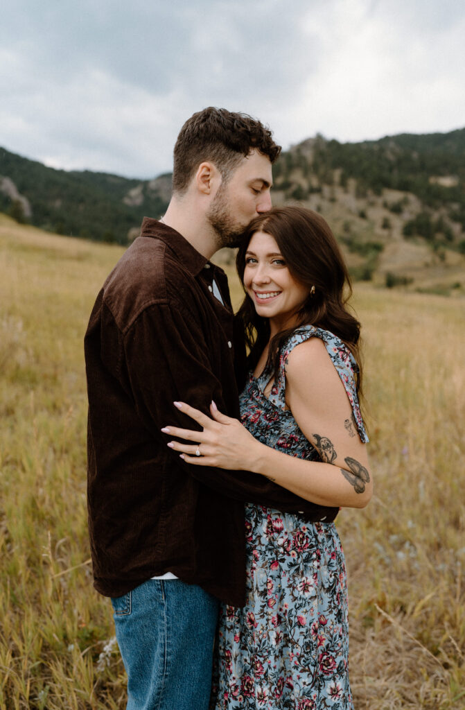 Couple holding each other and smiling during an engagement session in Boulder, CO