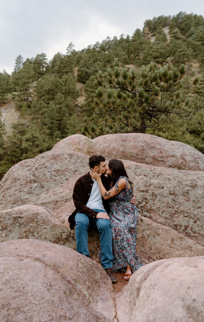Couple kissing on a rock during engagement session in Boulder, CO
