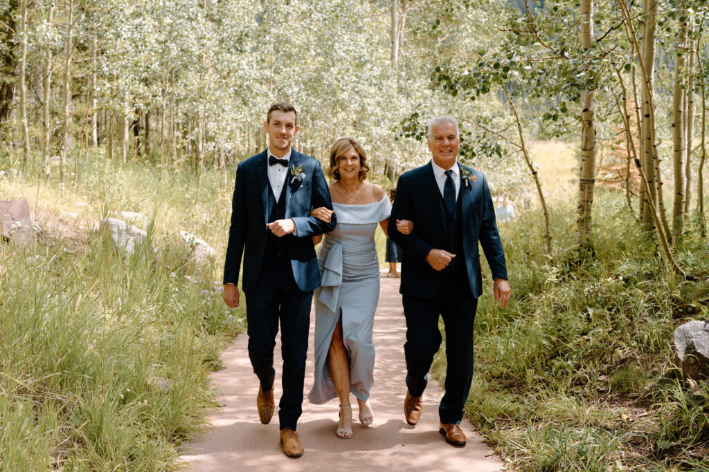 Groom and parents walking down aisle during an elopement at Maroon Bells