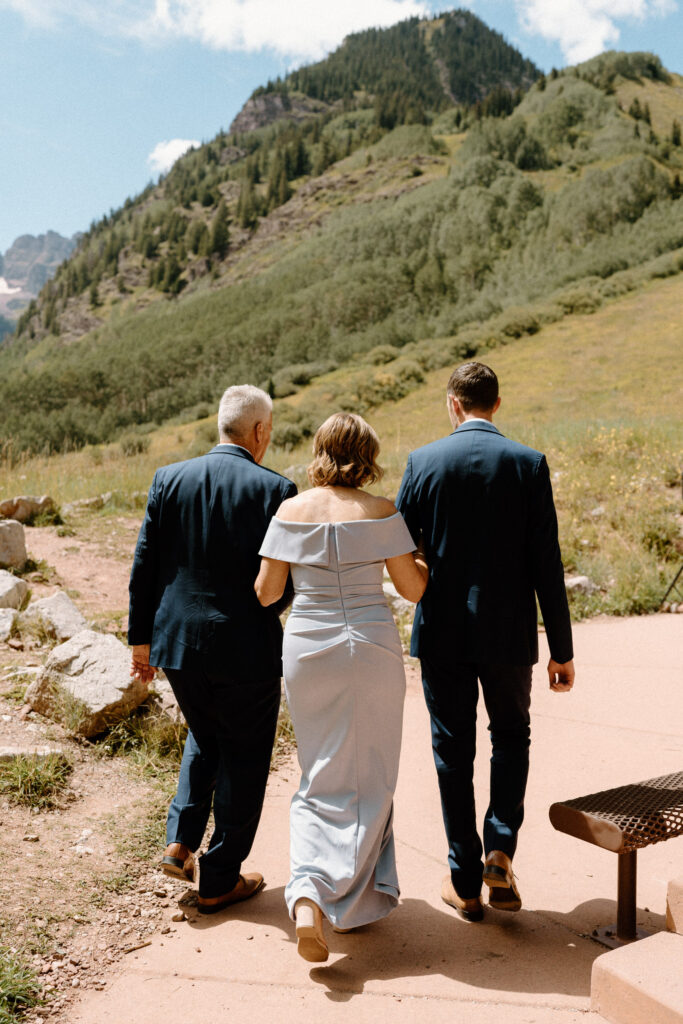 Groom and groom's parents walking down aisle during elopement at Maroon Bells