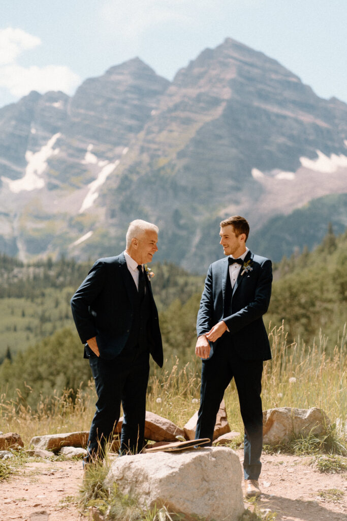 Groom laughing with dad during a ceremony of an elopement at Maroon Bells