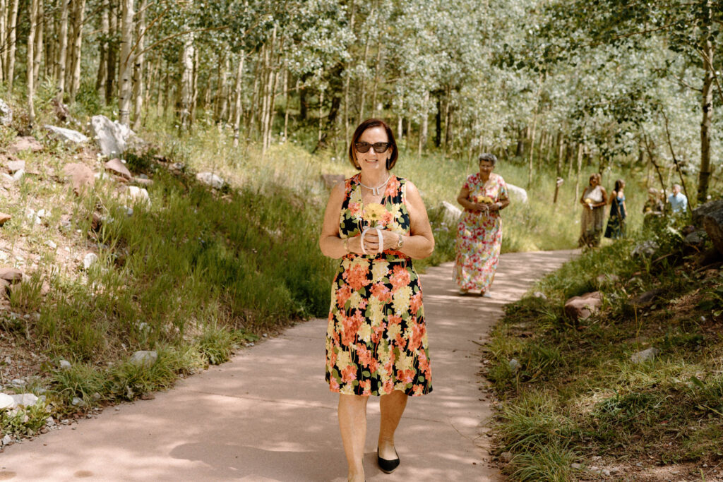 Bridesmaid smiling while walking down the aisle during an elopement at Maroon Bells