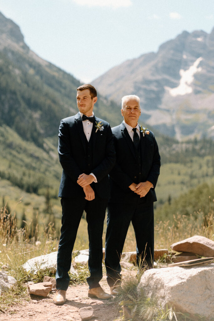 Groom watching bride walk down the aisle during an elopement at Maroon Bells