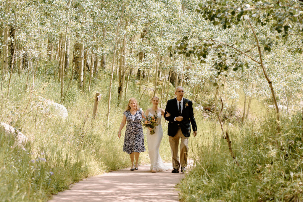 Bride and parents walking down the aisle during an elopement at Maroon Bells