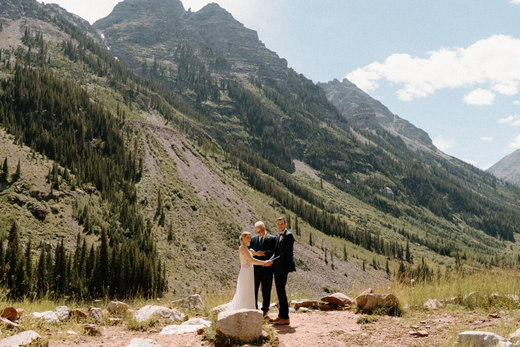 Groom laughing at wedding guests during elopement ceremony at Maroon Bells