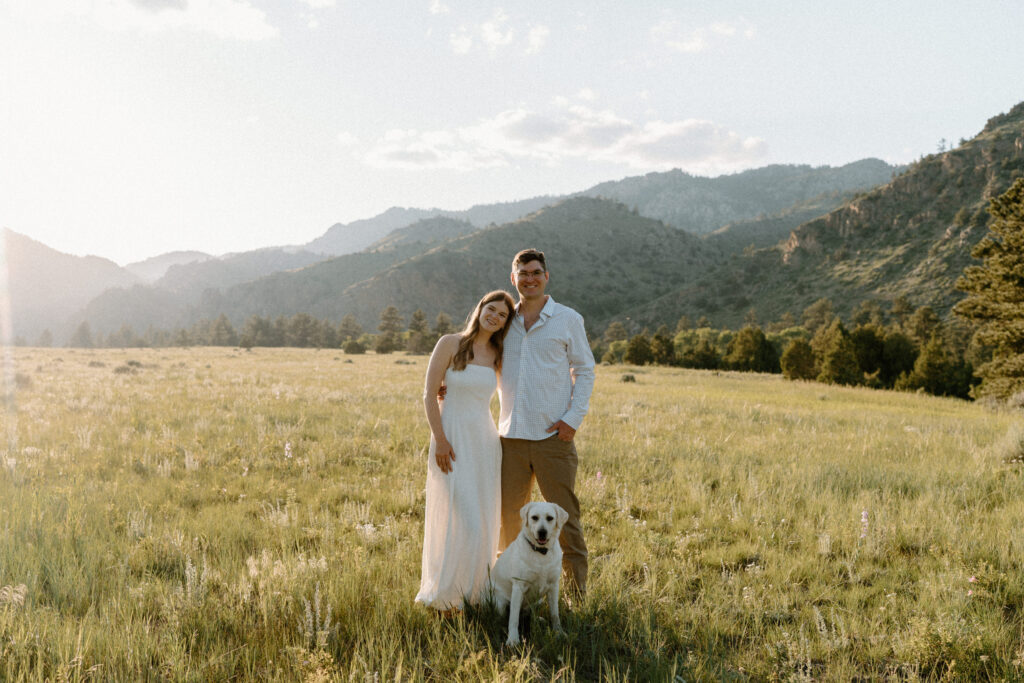 Couple smiling with their dog during engagement session at Poudre Canyon