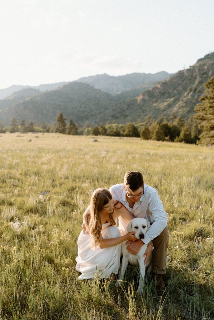Couple petting dog during engagement session at Poudre Canyon