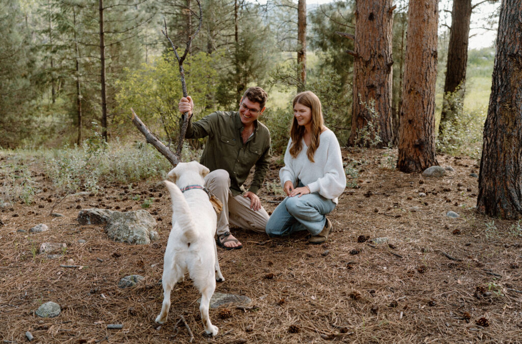 Couple playing with their dog during engagement session at Poudre Canyon