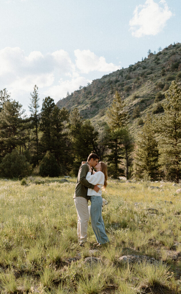 Couple kissing in a field during engagement session at Poudre Canyon