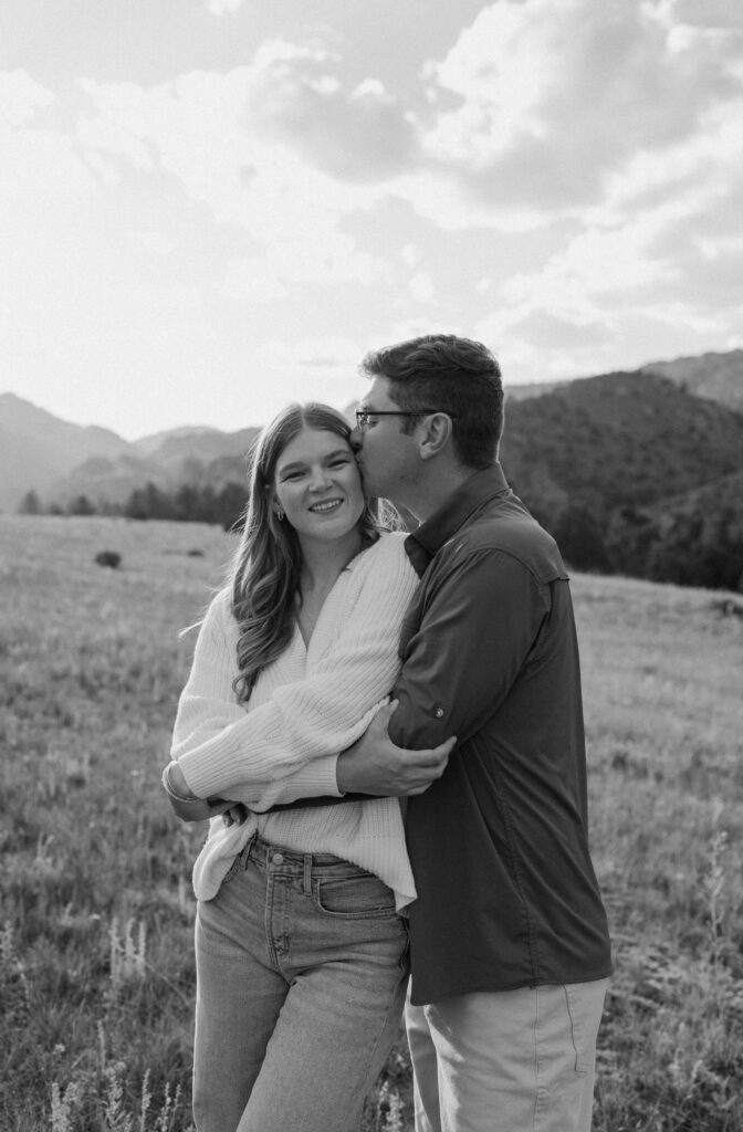Fiancé kissing fiancée's forehead during an engagement session at Poudre Canyon