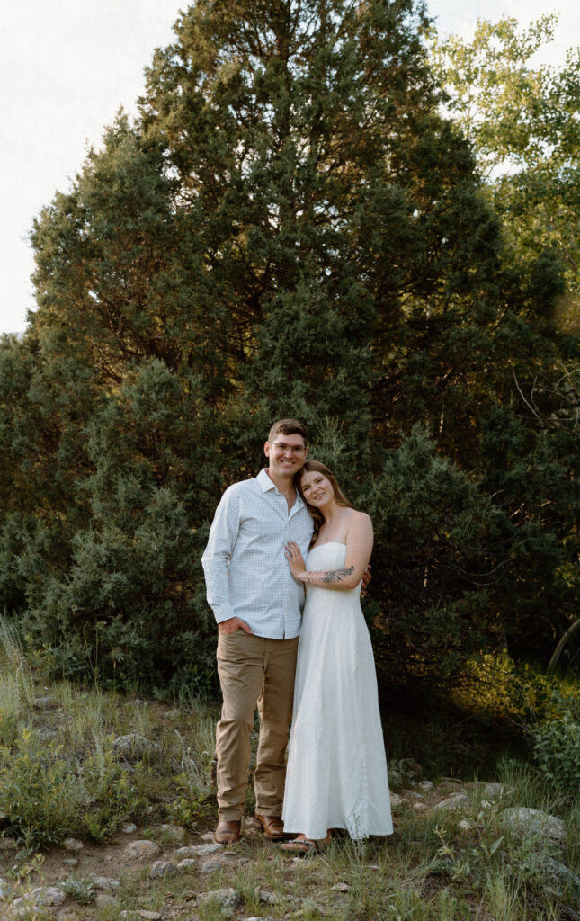 Couple smiling at the camera in Poudre Canyon during engagement session