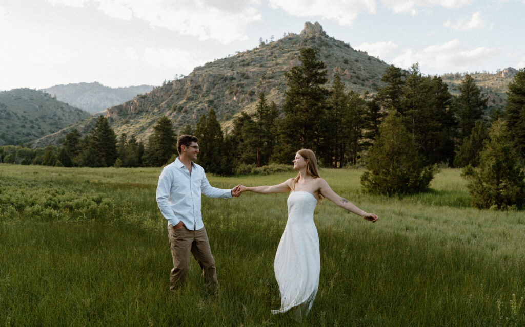 Couple dancing in a field during an engagement session in Poudre Canyon