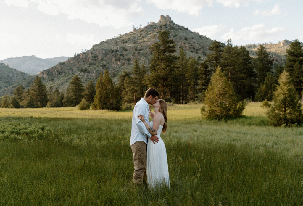 Couple kissing in a field at Poudre Canyon during engagement session