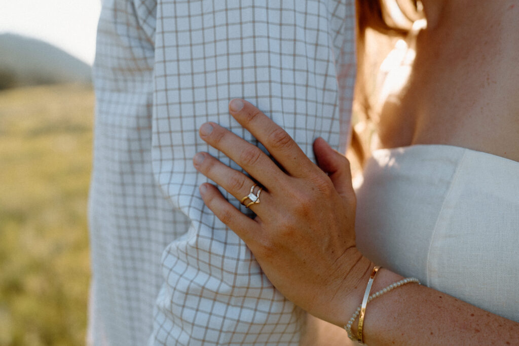 Fiancée holding fiancés arm showing engagement ring during a session at Poudre Canyon