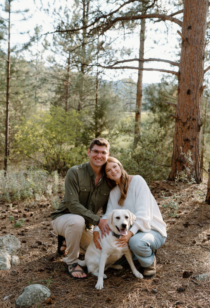 Couple smiling with their dog during engagement session in Poudre Canyon