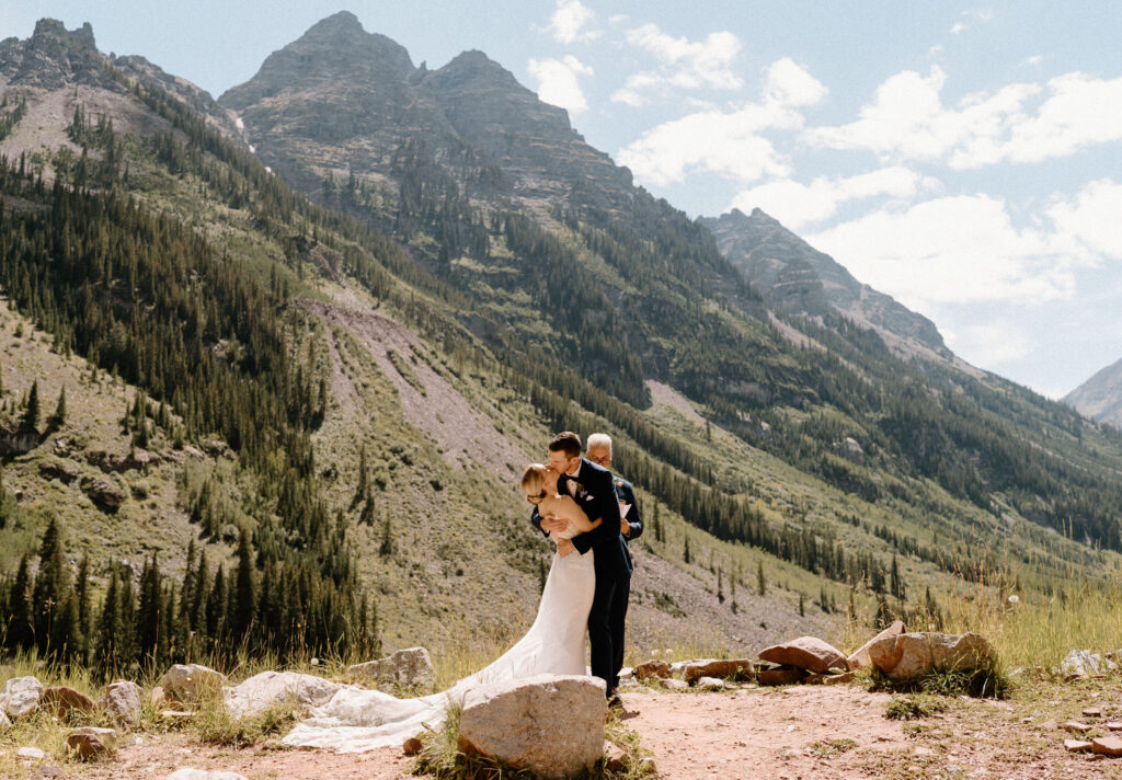 Bride and groom kissing during an elopement ceremony at Maroon Bells