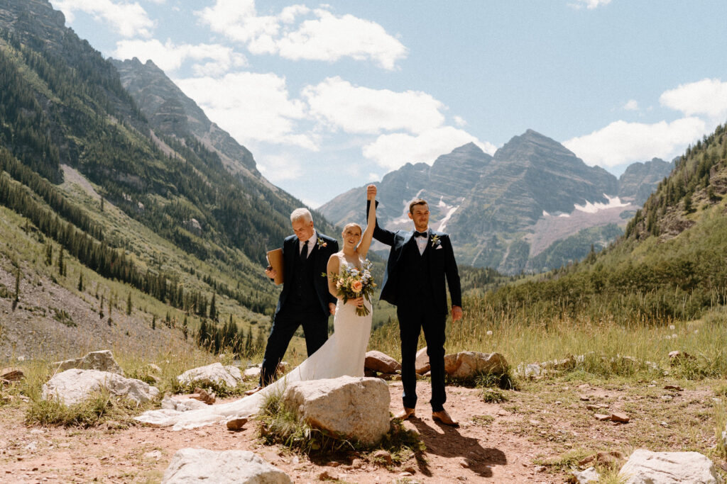 Bride and groom cheering after elopement ceremony at Maroon Bells