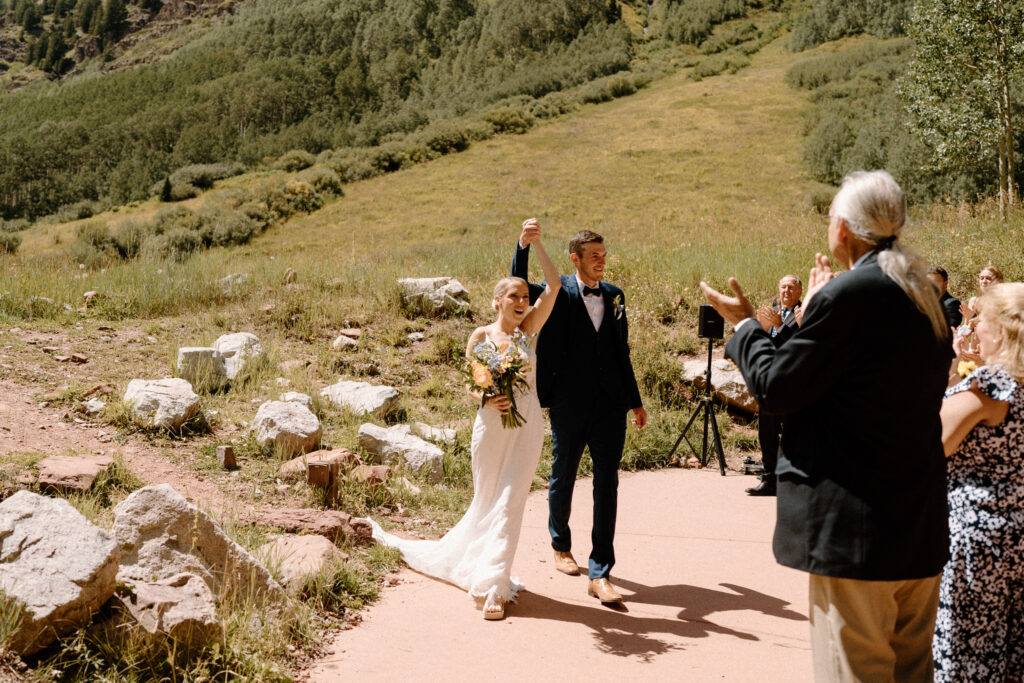 Bride and groom cheering at Maroon Bells after elopement ceremony