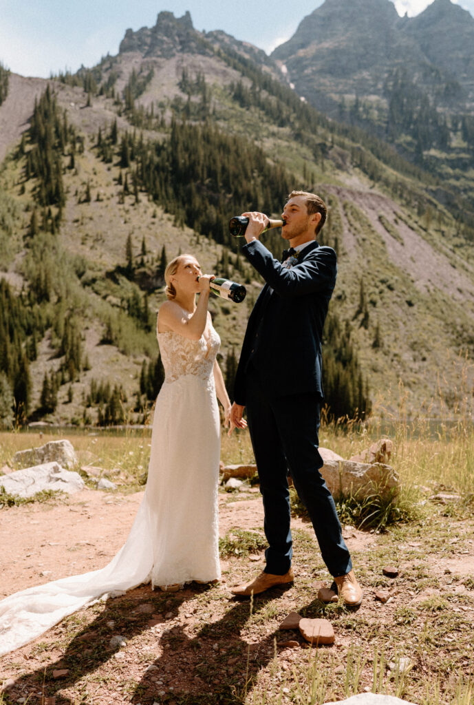 Bride and groom drinking champagne after elopement ceremony at Maroon Bells