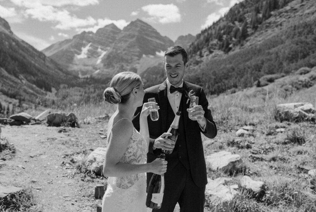 Bride and groom smiling with champagne during an elopement at Maroon Bells