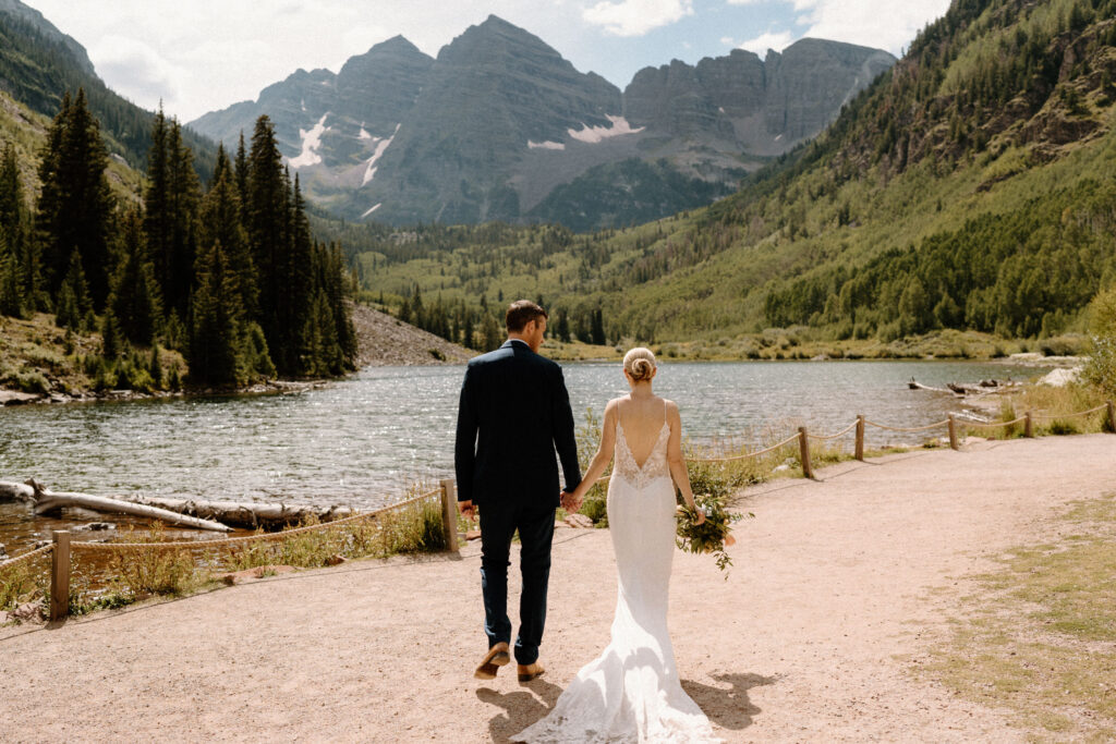 Bride and groom walking on at path at Maroon Bells during an elopement