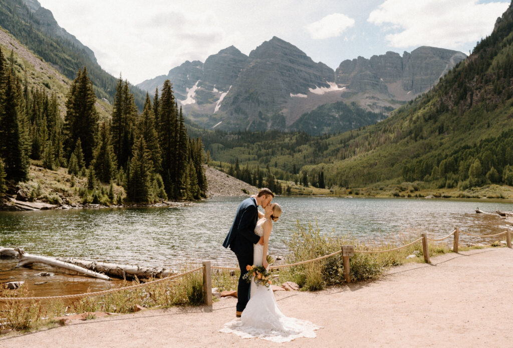 Bride and groom kissing in front of the Maroon Bells during elopement