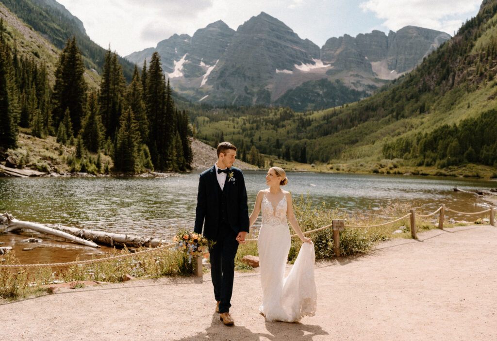 Bride and groom walking and smiling during an elopement at Maroon Bells