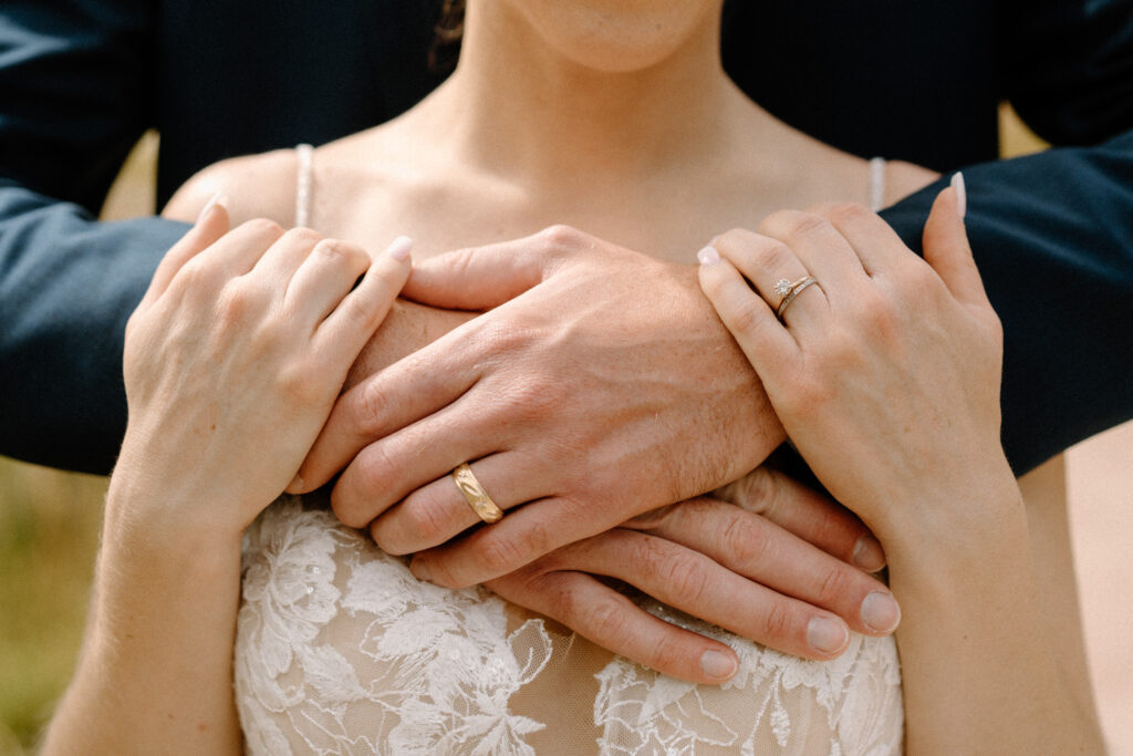 Bride and groom holding each other showing wedding rings during an elopement at Maroon Bells