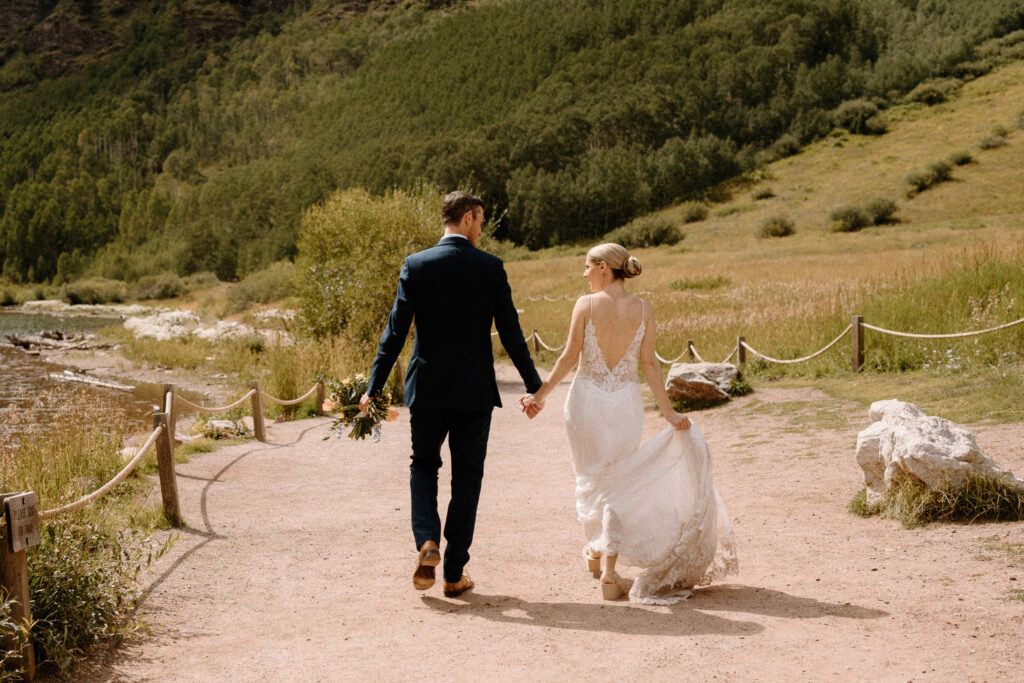 Bride and groom walking and holding hands during an elopement at Maroon Bells