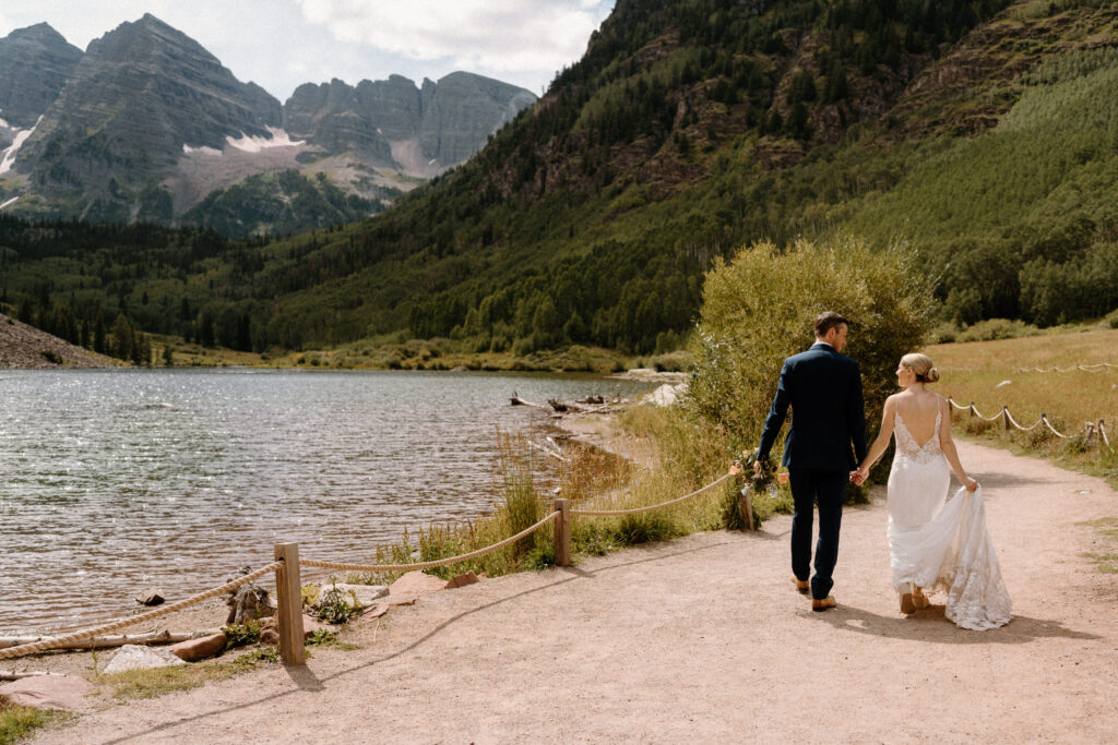 Bride and groom walking and smiling at each other during an elopement at Maroon Bells