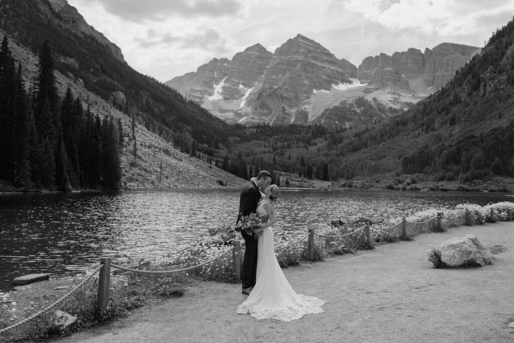 Bride and groom kissing in front of Maroon Bells during elopement