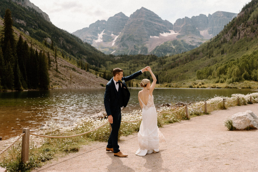 Groom twirling bride in front of Maroon Bells during an elopement at Maroon Bells