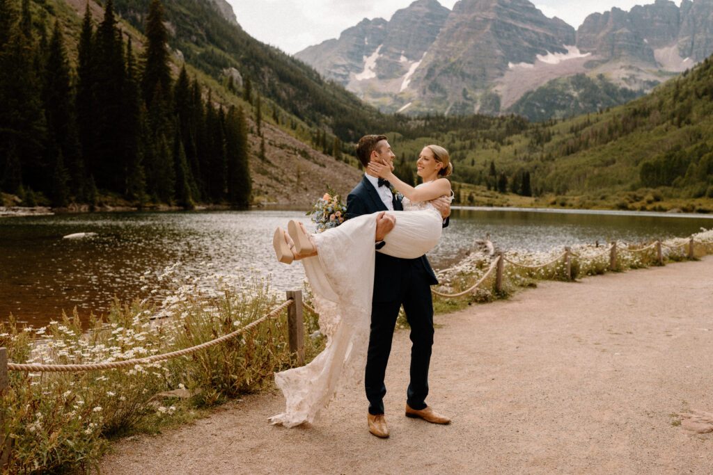 Groom carrying bride during an elopement at Maroon Bells