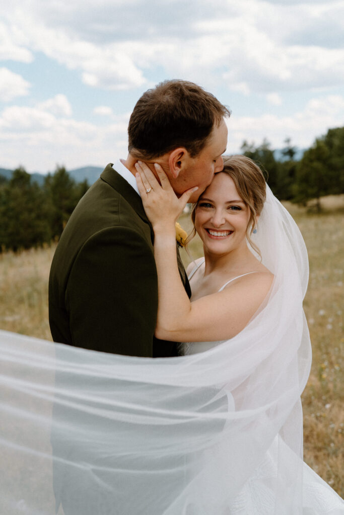 Bride smiling through veil on wedding day at Mt. Falcon