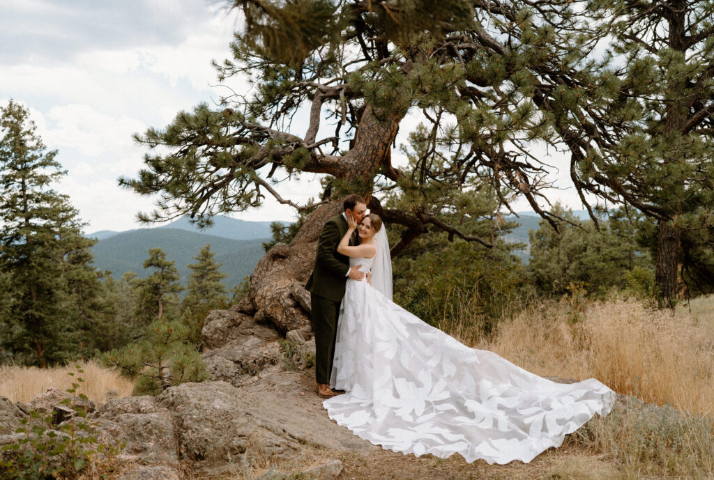 Groom kissing brides' cheek on wedding day at Mt. Falcon