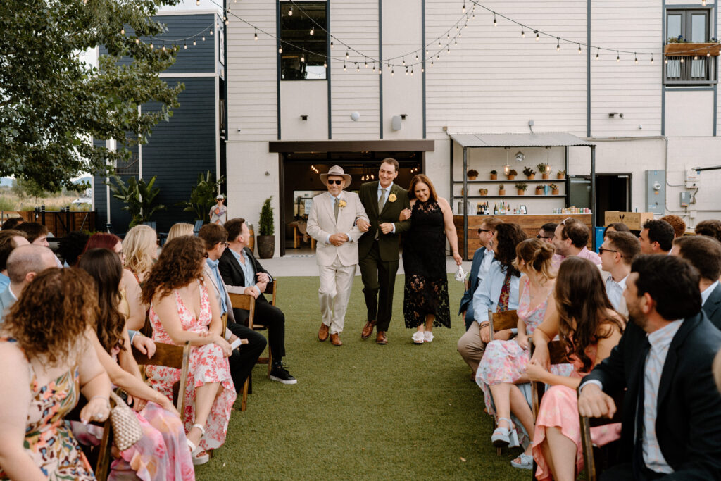 Groom and parents walking down the aisle on wedding day at Mountain Crust