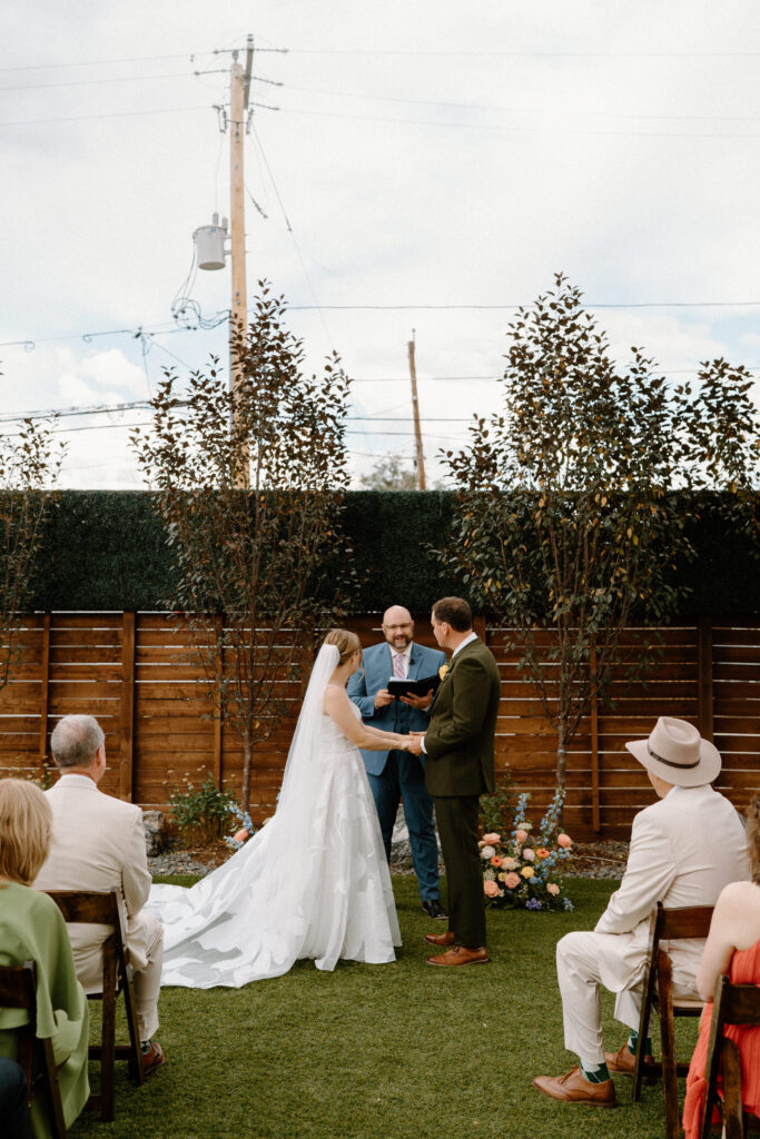 Bride and groom holding hands during ceremony at Mountain Crust