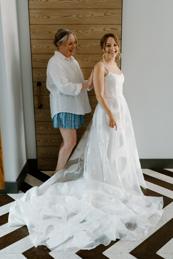 Bride's mom putting on wedding dress at the Maven Hotel in Denver