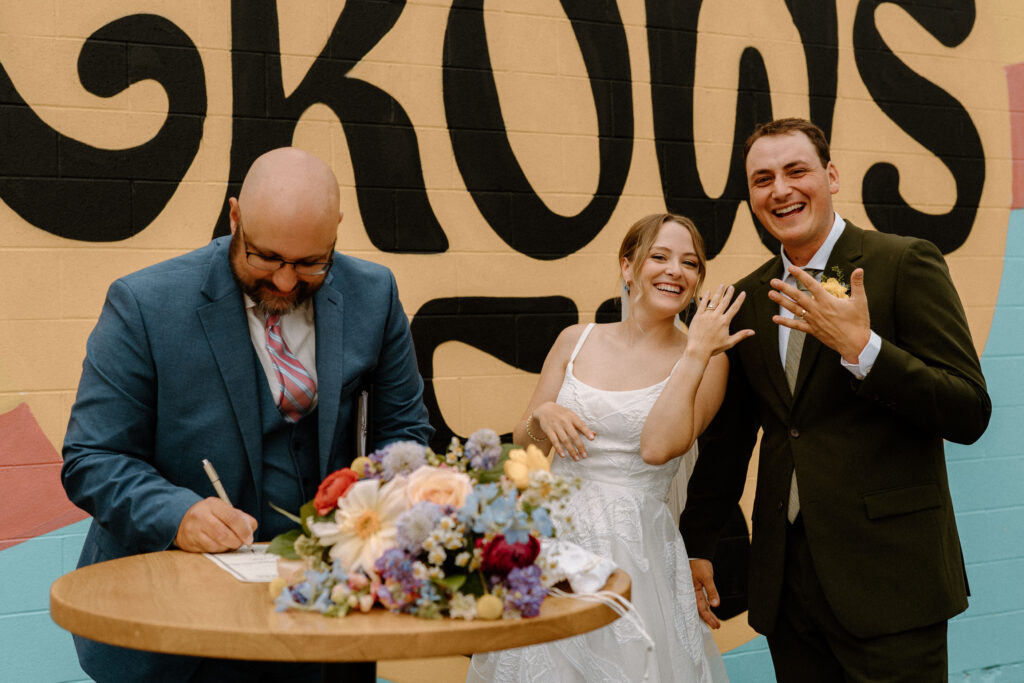 Bride and groom showing off rings on wedding day at Mountain Crust