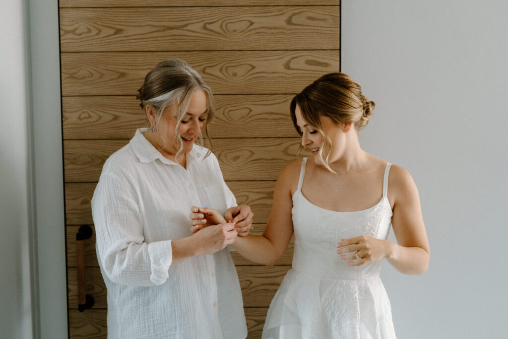 Bride's mom putting on bracelet on wedding day at the Maven in Denver