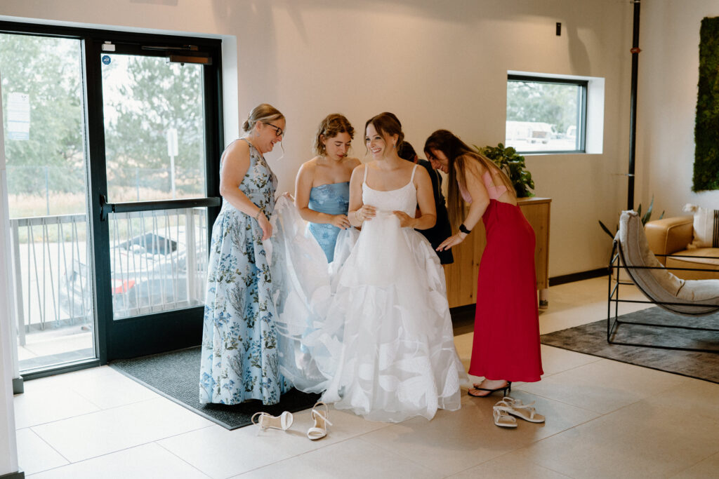 Wedding guests helping bride with dress at Mountain Crust