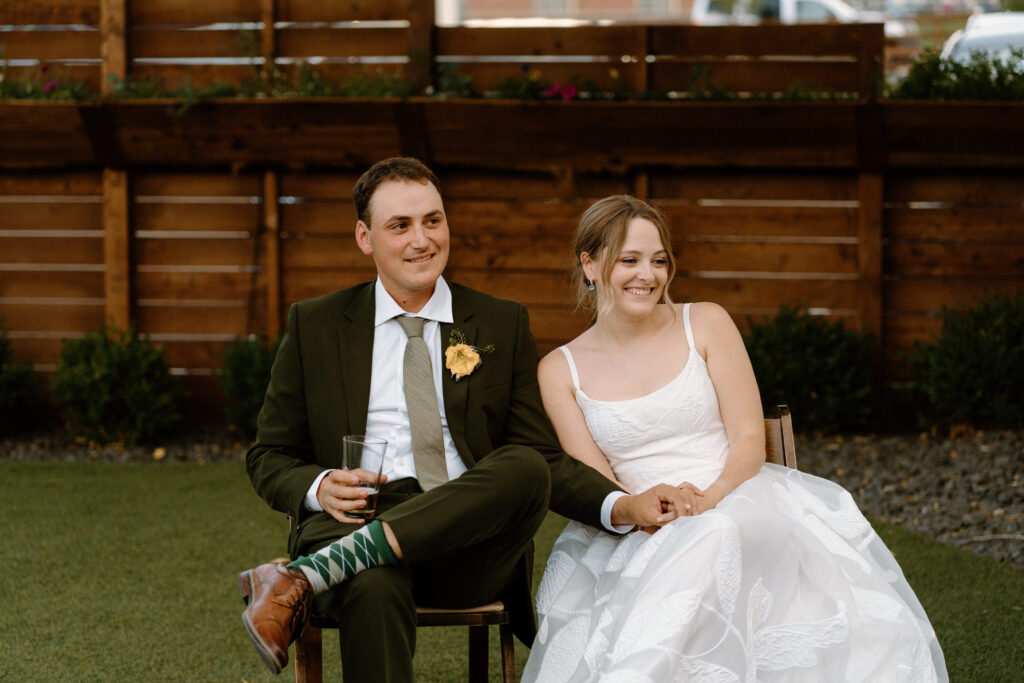 Bride and groom smiling during speeches on wedding day at Mountain Crust