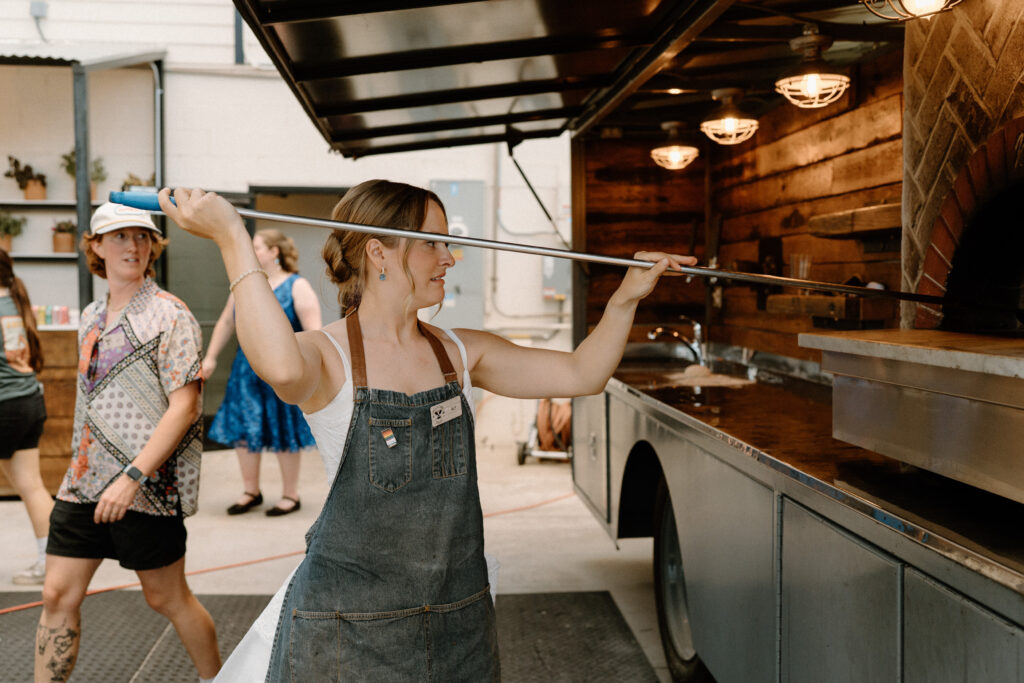 Bride using the pizza oven on wedding day at Mountain Crust