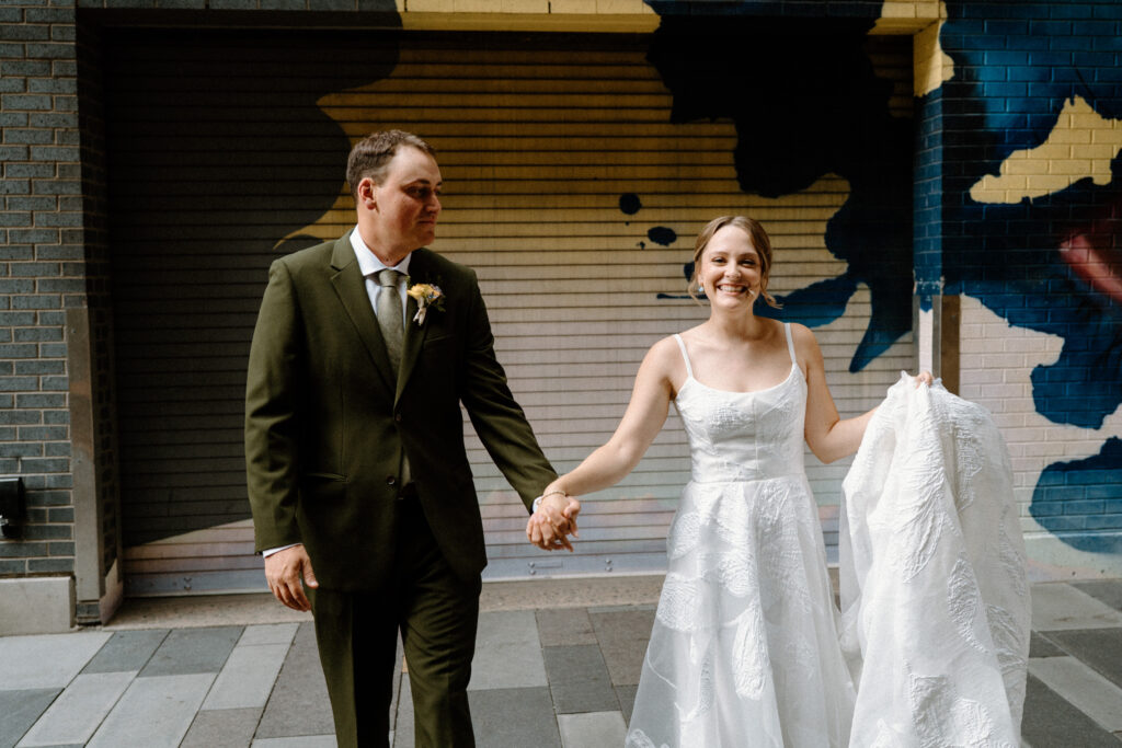 Bride and groom walking and holding hands during first look on wedding day in Denver