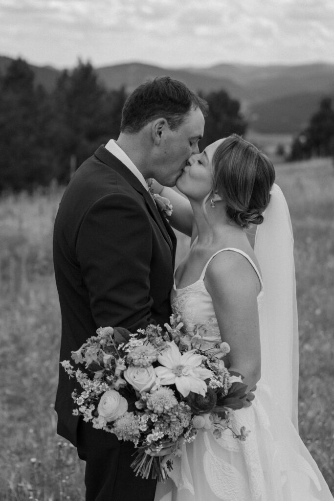 Bride and groom kissing at Mt. Falcon on wedding day 