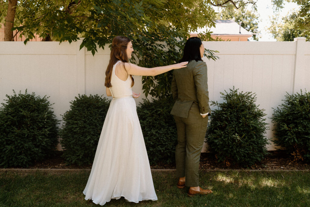 Bride tapping on bride's shoulder on wedding day at Sunrise Amphitheater 